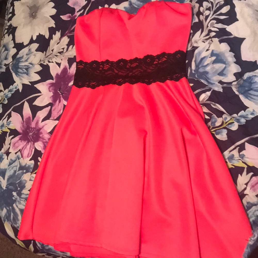 Hot pink, short dress with a black lace design.